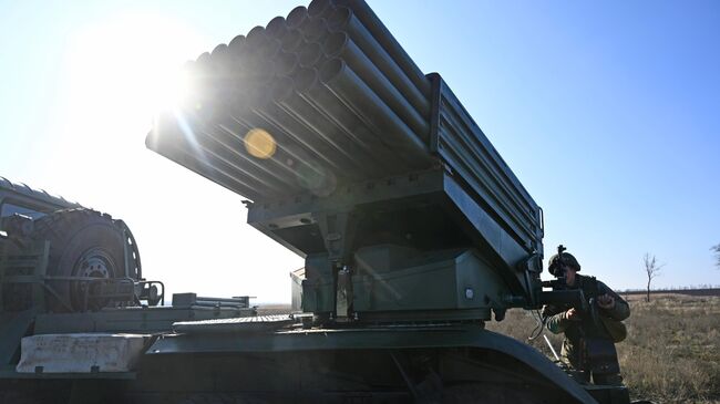 Военнослужащий 150-й мотострелковой дивизии подготавливает боевую машину БМ-21 реактивной системы залпового огня Град к боевым стрельбам