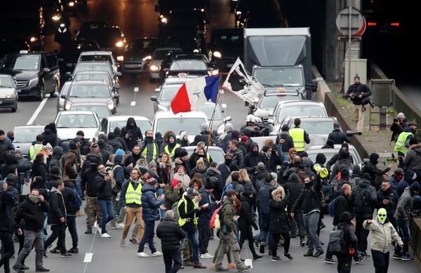 Протестующие во время демонстрации по случаю первой годовщины движения желтых жилетов в Париже