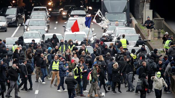 Протестующие во время демонстрации по случаю первой годовщины движения желтых жилетов в Париже