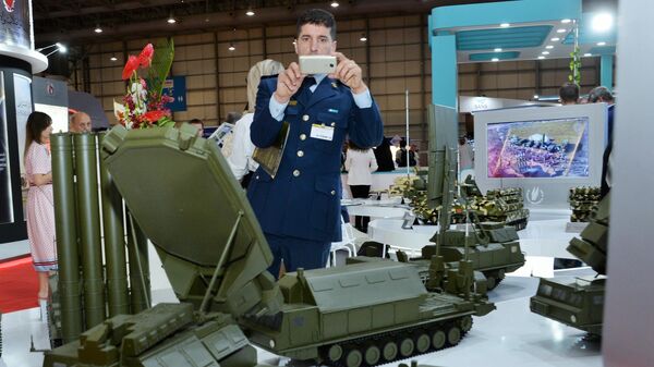 Посетитель выставки осматривает макеты военной техники, представленные на стенде АО Рособоронэкспорт на международном авиасалоне Dubai Airshow 2019 в Дубае