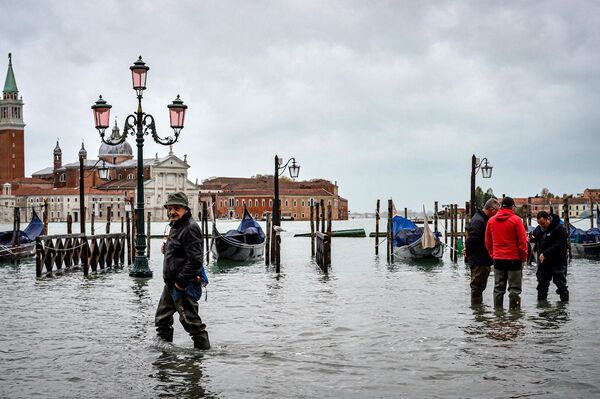Прохожие на одной из улиц в Венеции во время наводнения