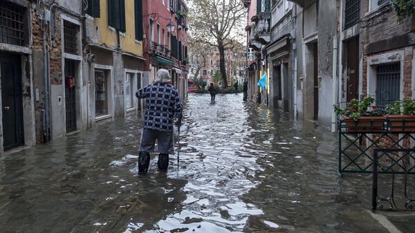 Прохожий на одной из улиц в Венеции во время наводнения