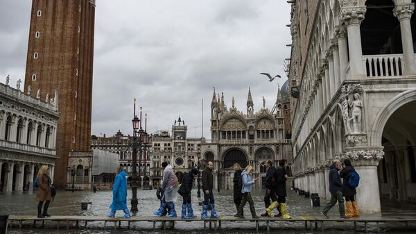 Прохожие в окрестностях площади Сан-Марко в Венеции во время наводнения
