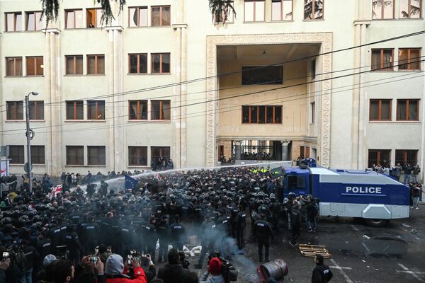 Сотрудники грузинского спецназа разгоняют акцию оппозиционеров у здания парламента Грузии