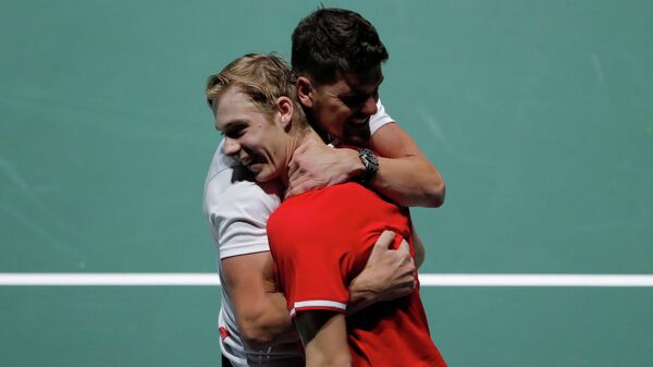 Tennis - Davis Cup Finals - Caja Magica, Madrid, Spain - November 18, 2019   Canada's Denis Shapovalov is embraced by captain Frank Dancevic as he celebrates after winning his group stage match against Italy's Matteo Berrettini   REUTERS/Susana Vera