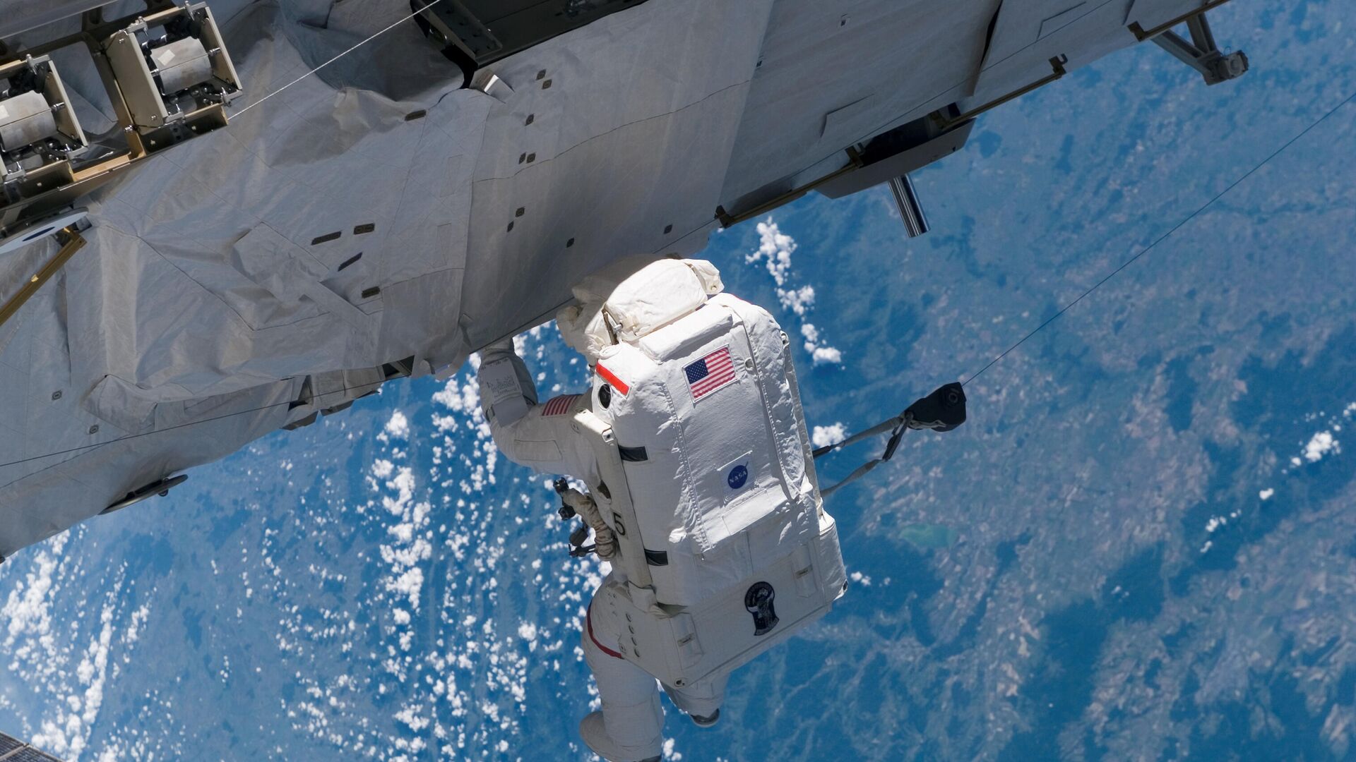 Американский астронавт во время выхода в открытый космос на МКС - РИА Новости, 1920, 20.06.2021