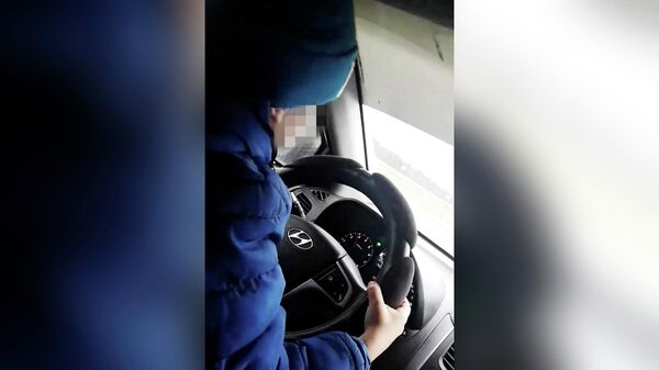 Стоп-кадр видео ребенка за рулем автомобиля