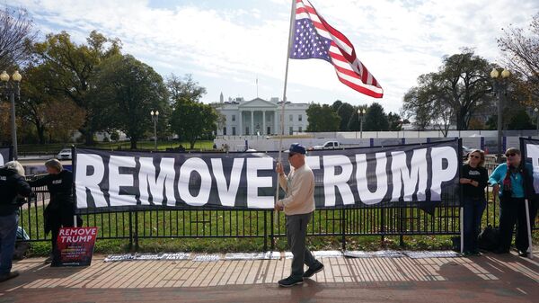 Активисты держат плакат с просьбой об импичменте президента США Дональда Трампа