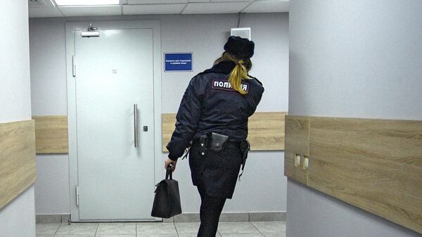 Сотрудница  полиции идет по коридору дежурной части