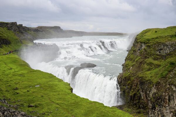Посетители у водопада Гюдльфосс в Исландии