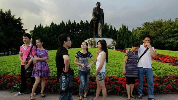 Люди перед памятником Дэн Сяопину в парке в Шэньчжэне, Китай