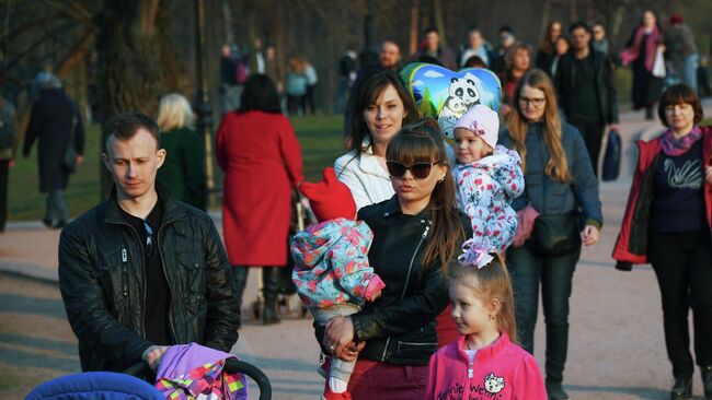 Молодая семья с детьми во время прогулки в парке