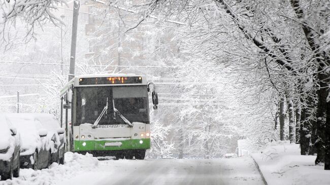 Автобус движется по заснеженной улице