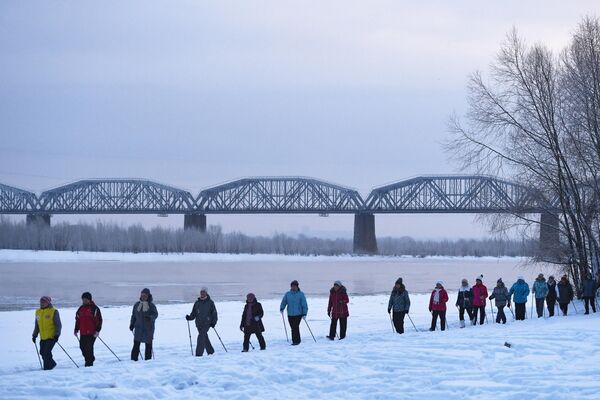 Женщины во время проведения бесплатных занятий по скандинавской ходьбе на берегу реки Обь в Новосибирске