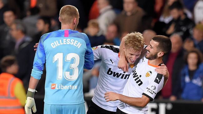 Valencia's Dutch  goalkeeper Cillesen (L), Valencia's Danish midfielder Daniel Wass and Valencia's Spanish defender Jose Gaya celebrate at the end of the Spanish league football match between Valencia CF and Villarreal CF at the Mestalla stadium in Valencia on November 30, 2019. (Photo by JOSE JORDAN / AFP)