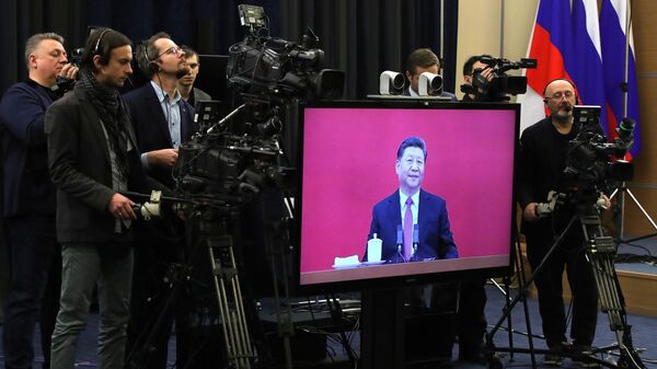 Журналисты у монитора с изображением председателя КНР Си Цзиньпина