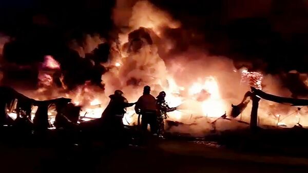 Сотрудники противопожарной службы МЧС России тушат пожар в ангаре на территории промышленной зоны в Санкт-Петербурге. Стоп-кадр с видео, предоставленного МЧС