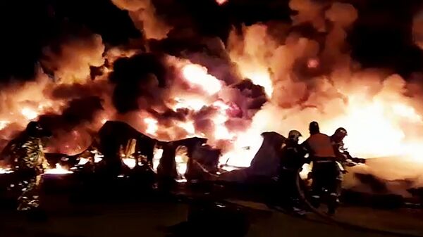 Сотрудники МЧС России тушат пожар в ангаре на территории промышленной зоны в Санкт-Петербурге. Стоп-кадр с видео, предоставленного МЧС