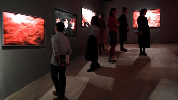 Посетители выставки работ фотографа Арсена Ревазова Невидимый свет в Третьяковской галерее