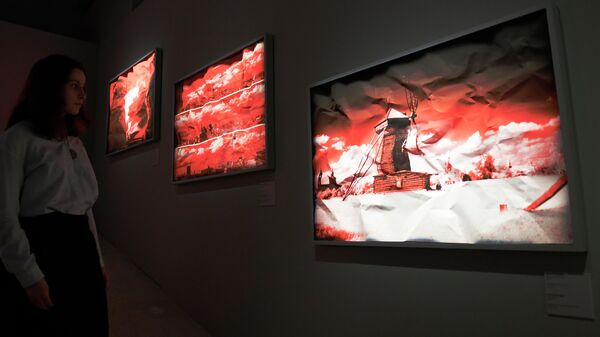 Посетительница выставки работ фотографа Арсена Ревазова Невидимый свет в Третьяковской галерее