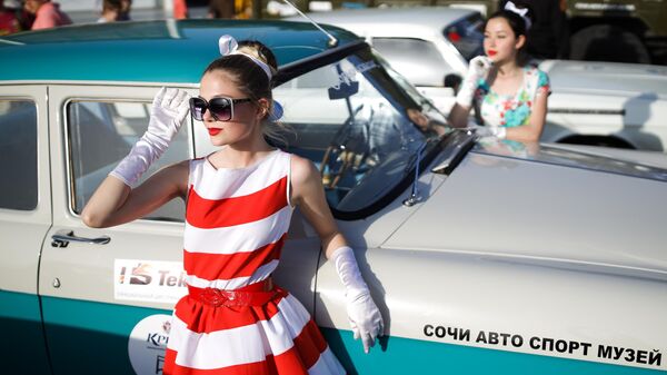 Девушки фотографируются возле автомобиля ГАЗ-21 Волга