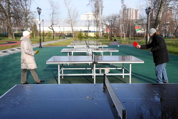 Отдыхающие играют в настольный теннис на территории Детского Черкизовского парка в Москве