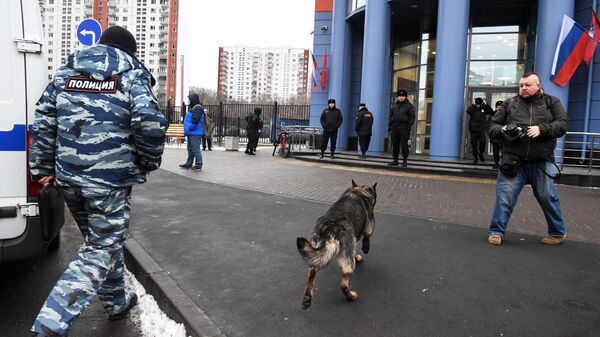 Сотрудник полиции со служебной собакой у здания Тверского суда Москвы, в котором проходит эвакуация в связи с получением анонимного сообщения о заложенном в здании взрывном устройстве