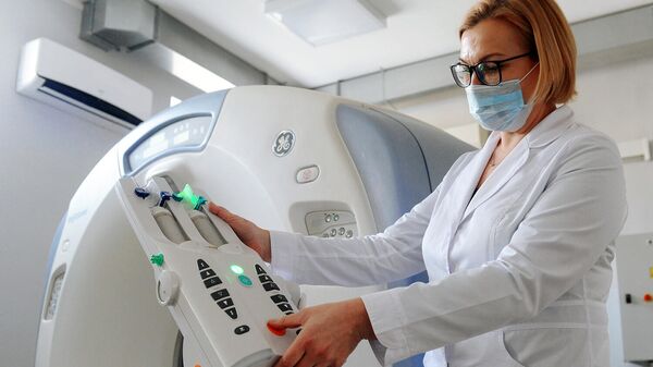 Медицинский работник подготавливает аппарат компьютерной томографии к работе