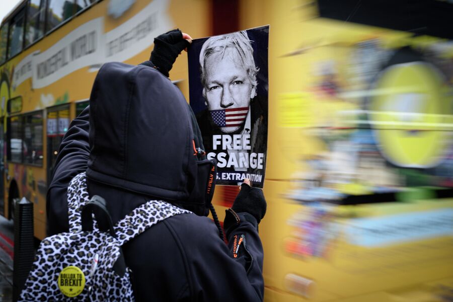 Участник акции против преследования основателя Wikileaks Джулиана Ассанжа держит в руках листовку с призывом освободить Дж. Ассанжа