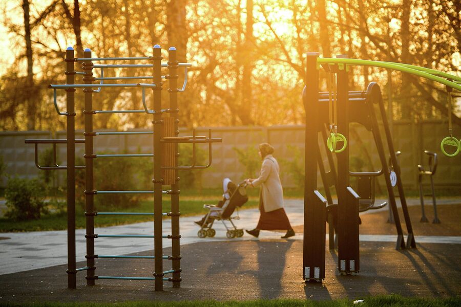Женщина с ребенком проходит мимо спортивной площадки в Капотне