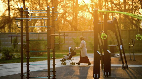 Женщина с ребенком проходит мимо спортивной площадки в Капотне