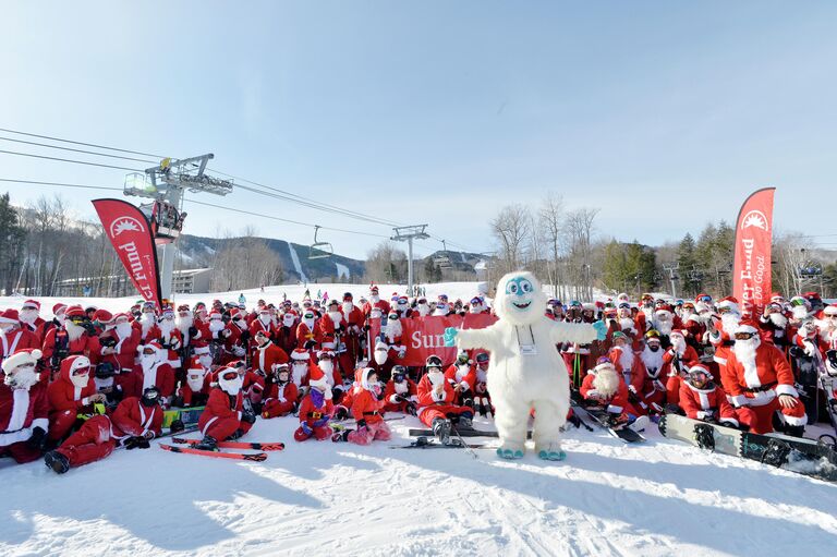 Лыжники одетые как Санта Клаус участвуют в ежегодном благотворительном мероприятии на горнолыжном курорте Sunday River в Ньюри, штат Мэн