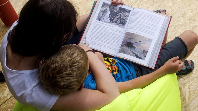 Мать с ребенком читают книгу