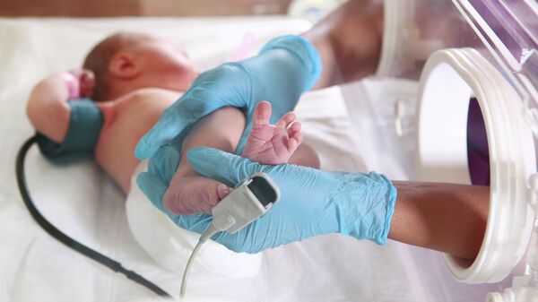 Новорожденный в отделении интенсивной терапии в медицинском инкубаторе