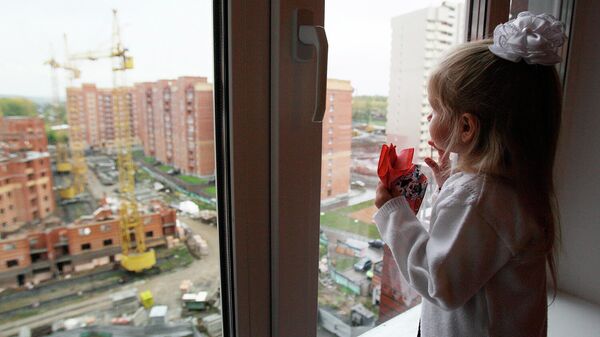 Девочка смотрит из окна новостройки