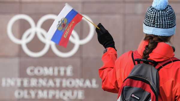 Болельщица с российским флагом на фоне штаб-квартиры Международного олимпийского комитета (МОК) в Лозанне (Швейцария)