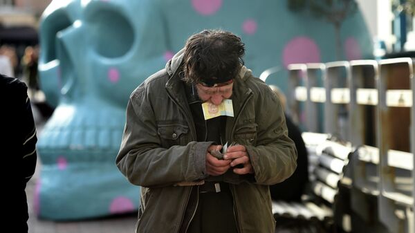 Мужчина считает деньги возле уличного кафе в центре Киева, Украина