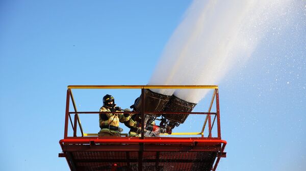 Сотрудники пожарной службы тушат очаг возгорания 