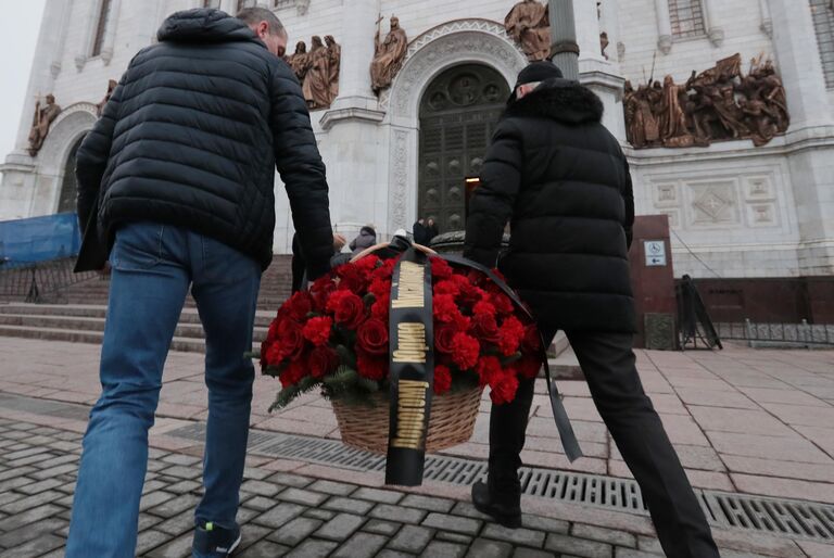 Люди несут цветы на церемонию прощания с бывшим мэром Москвы Юрием Лужковым