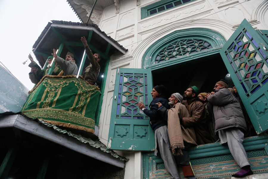 Кашмирские мусульмане молятся, когда священник показывает реликвию суфийского святого шейха в Сринагаре
