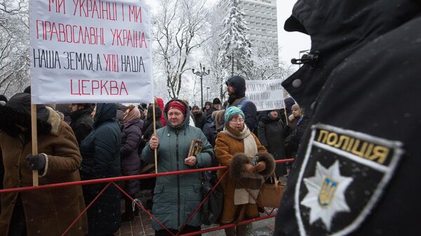 Верующие, протестующие против лишения канонической Украинской православной церкви ее названия, у здания Верховной рады Украины в Киеве