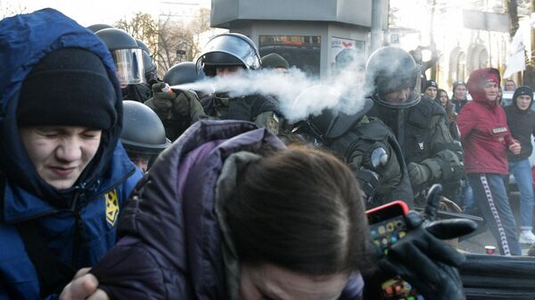 Сотрудники полиции используют слезоточивый газ против участников акции протеста против земельной реформы возле здания Верховной рады в Киеве. 17 декабря 2019