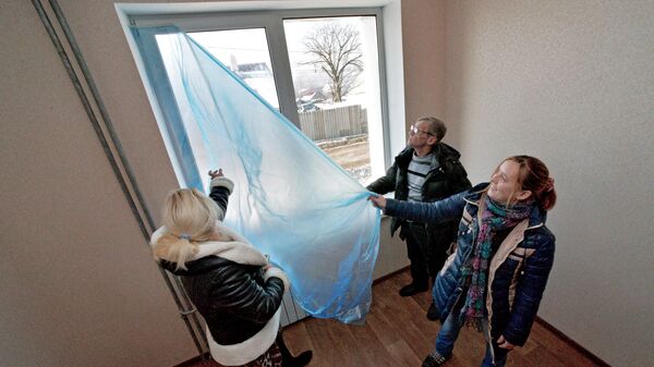Жители Владивостока осматривают квартиру в новом доме, построенном по программе переселения людей из аварийного жилья
