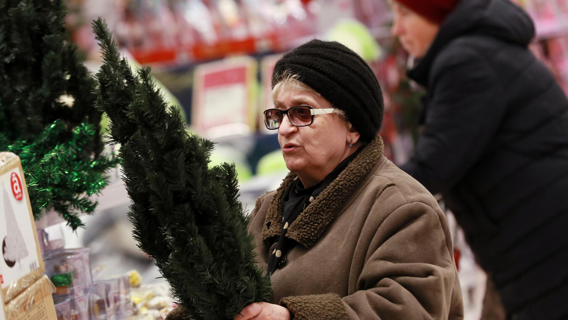 Женщина выбирает новогоднюю ёлку в гипермаркете Ашан в Москве - РИА Новости, 1920, 01.12.2020
