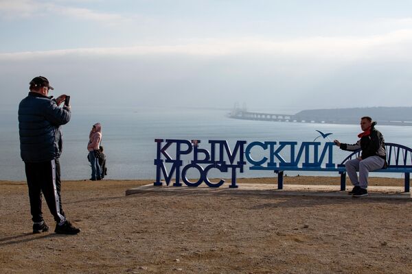 Люди фотографируются напротив Крымского моста