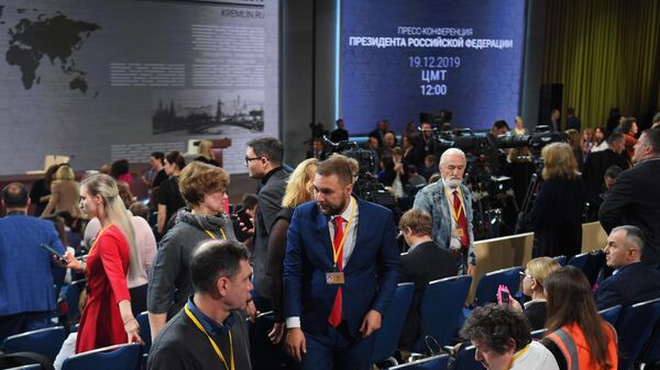 Журналисты с плакатами перед началом ежегодной большой пресс-конференции президента РФ Владимира Путина 