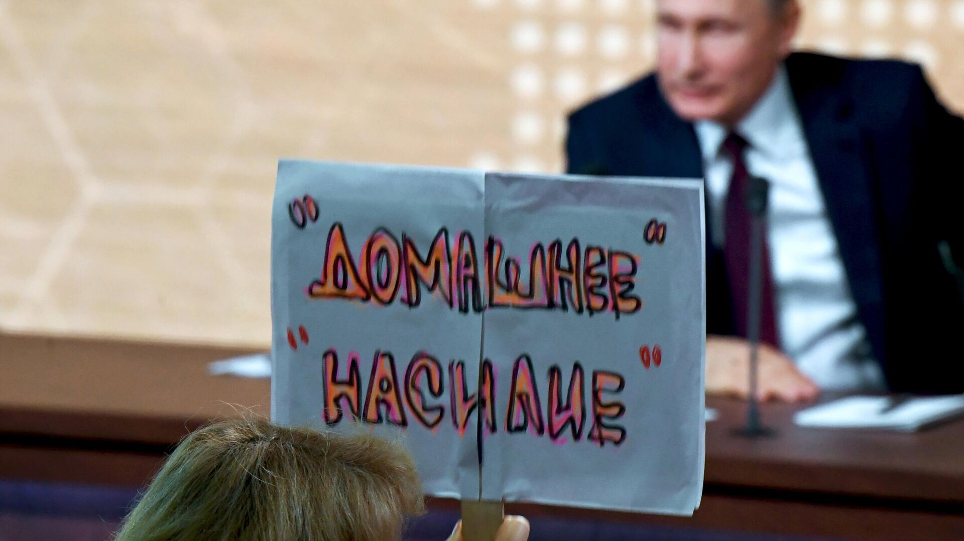 Журналист с плакатом Домашнее насилие во время большой ежегодной пресс-конференции президента РФ Владимира Путина  - РИА Новости, 1920, 14.04.2021