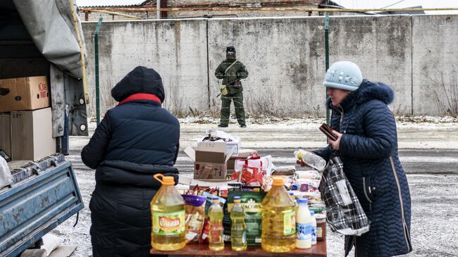 Российский пограничник наблюдает за стихийным рынком на украинской стороне
