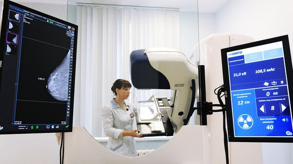 Лаборант настраивает цифровой маммограф