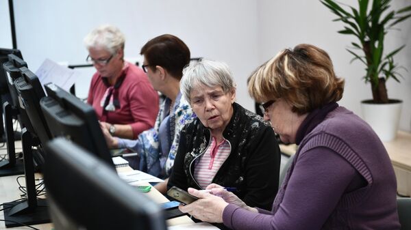 Пенсионеры во время обучения работы на компьютере